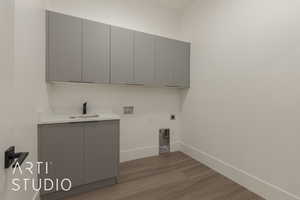 Laundry room with sink, dark wood-type flooring, electric dryer hookup, cabinets, and washer hookup