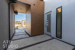 View of exterior entry with a patio area