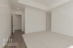 Spare room with dark hardwood / wood-style floors and a raised ceiling