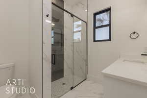 Bathroom featuring toilet, vanity, and walk in shower