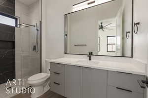 Bathroom with hardwood / wood-style flooring, ceiling fan, vanity, toilet, and walk in shower