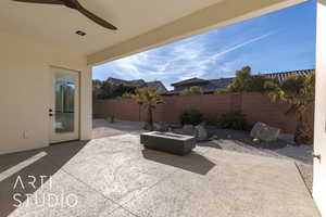 View of patio with ceiling fan and an outdoor fire pit