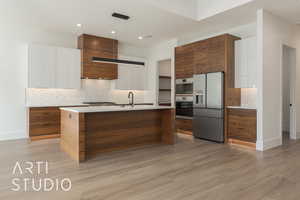 Kitchen with white cabinetry, tasteful backsplash, light hardwood / wood-style flooring, pendant lighting, and stainless steel appliances