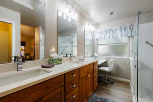 Bathroom featuring hardwood / wood-style flooring, vanity, and a shower with shower door