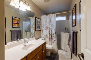 Bathroom featuring vanity, toilet, and a shower with shower curtain