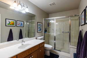 Bathroom with vanity, an enclosed shower, and a notable chandelier