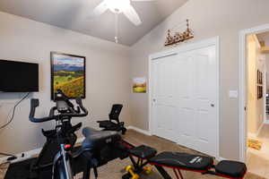 Exercise area featuring lofted ceiling, carpet, and ceiling fan