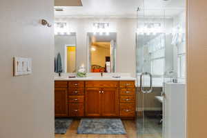 Bathroom featuring a shower with door, vanity, and hardwood / wood-style floors