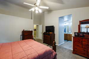 Bedroom featuring connected bathroom, light carpet, and ceiling fan