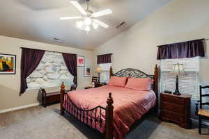 Carpeted bedroom featuring vaulted ceiling and ceiling fan