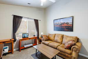 Carpeted living room featuring ceiling fan