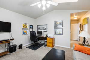 Office space featuring ceiling fan, lofted ceiling, and light carpet