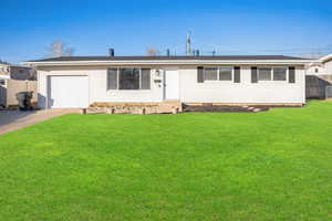 Ranch-style house with a garage and a front lawn