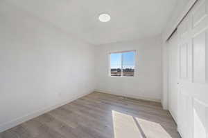 Unfurnished bedroom featuring a closet and light wood-type flooring