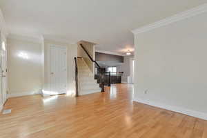 Empty room with light hardwood / wood-style flooring and ornamental molding