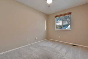 Carpeted spare room with ceiling fan