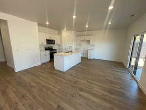 Kitchen with sink, appliances with stainless steel finishes, white cabinets, a center island with sink, and dark hardwood / wood-style flooring