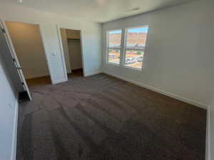 Unfurnished bedroom featuring dark colored carpet