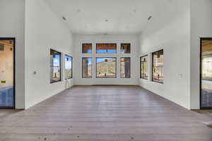 Unfurnished living room with a high ceiling and hardwood / wood-style flooring