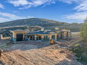 Rear view of house with a chimney, an attached garage, a mountain view, and french doors