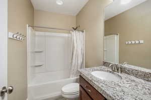 Full bathroom featuring vanity, toilet, and shower / tub combo