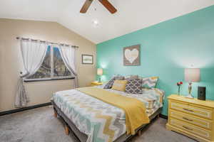 Carpeted bedroom with vaulted ceiling and ceiling fan