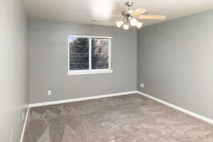 Spare room with carpet floors and ceiling fan