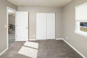 Unfurnished bedroom with carpet and a closet