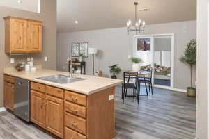 Kitchen featuring sink, hanging light fixtures, kitchen peninsula, and dishwasher