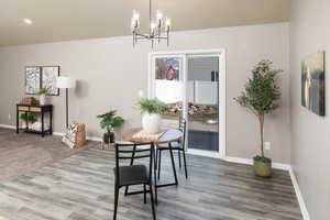 Dining space with wood-type flooring and a notable chandelier