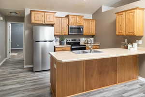 Kitchen featuring appliances with stainless steel finishes, light brown cabinetry, sink, and light hardwood / wood-style flooring