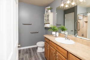 Bathroom featuring a shower, hardwood / wood-style floors, vanity, and toilet