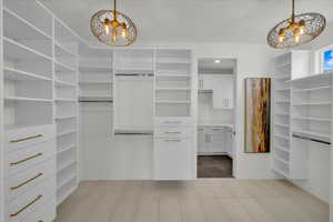 Walk in closet featuring a notable chandelier