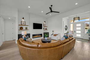 Living room with ceiling fan and light wood-type flooring