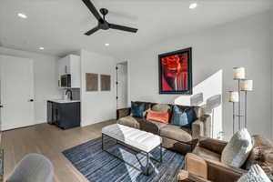 Living room featuring ceiling fan, sink, and light hardwood / wood-style floors