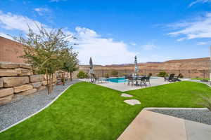 View of yard featuring a fenced in pool, a mountain view, and a patio area