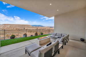 View of patio with a mountain view and an outdoor living space with a fire pit