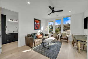 Living room with ceiling fan and light hardwood / wood-style floors