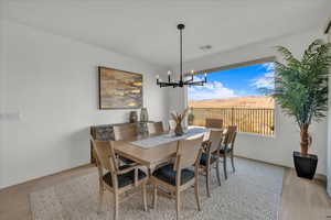 Dining area featuring light wood-type flooring and a notable chandelier