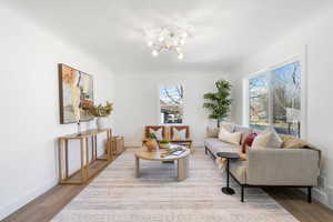 Living room featuring a notable chandelier and wood-type flooring