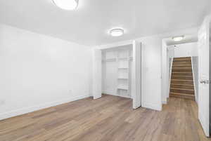 Unfurnished bedroom with light hardwood / wood-style flooring and a closet