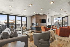 Living room with a healthy amount of sunlight, a textured ceiling, and light wood-type flooring