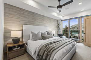 Bedroom featuring tile walls, access to exterior, and ceiling fan