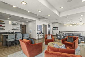 Living room featuring wet bar, a textured ceiling, and light wood-type flooring