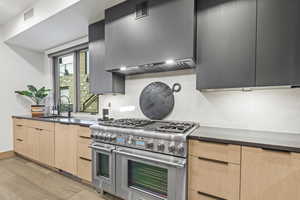 Kitchen featuring light hardwood / wood-style flooring, sink, range with two ovens, and light brown cabinets