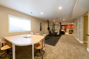 Dining space with a stone fireplace and light colored carpet