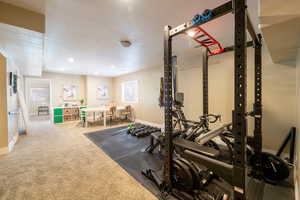 Exercise area featuring carpet floors and a textured ceiling