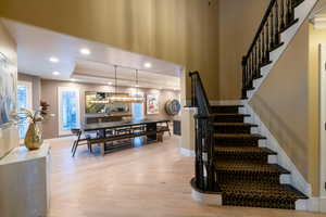 Stairway featuring a raised ceiling and parquet floors