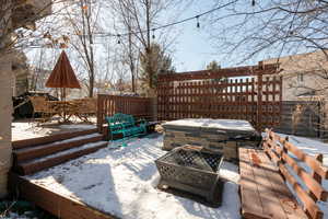 Snow covered deck featuring a fire pit