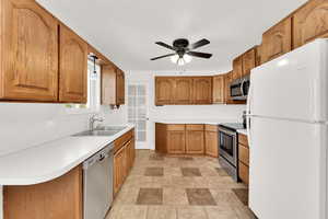 Kitchen featuring ceiling fan, stainless steel appliances, and sink